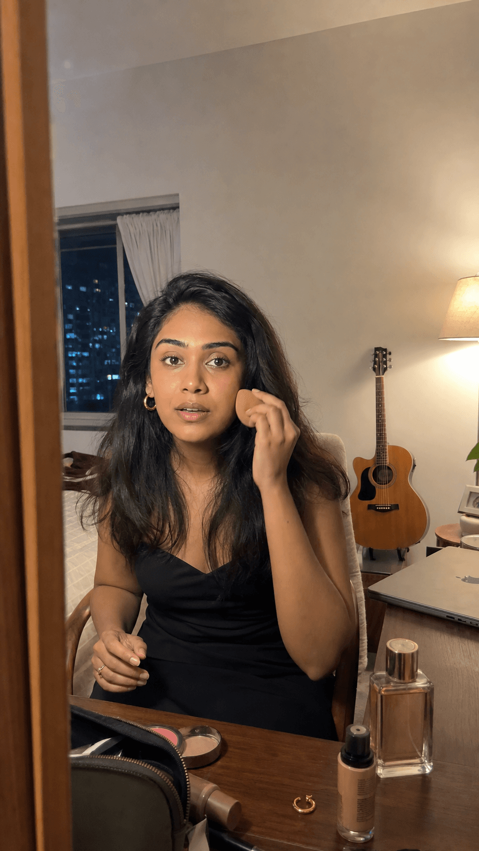 The same woman getting ready for dinner with her laptop closed and guitar behind her